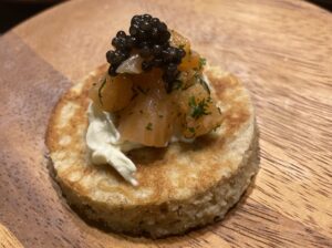 Organic rye blini topped with salmon tartare and premium caviar 